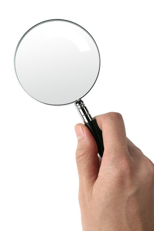 Hand holding magnifying glass